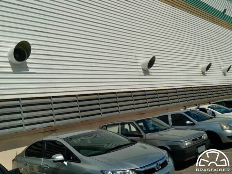 Exaustores de parede no alto da fachada e venezianas de entrada de ar embaixo, em galpão logístico