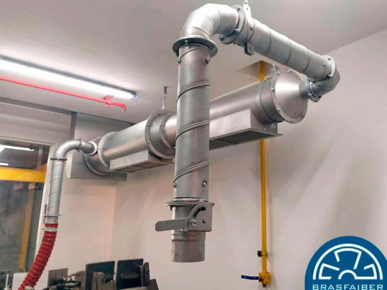 Rede de dutos de exaustão localizada captando fumos e vapores sobre a linha de produção