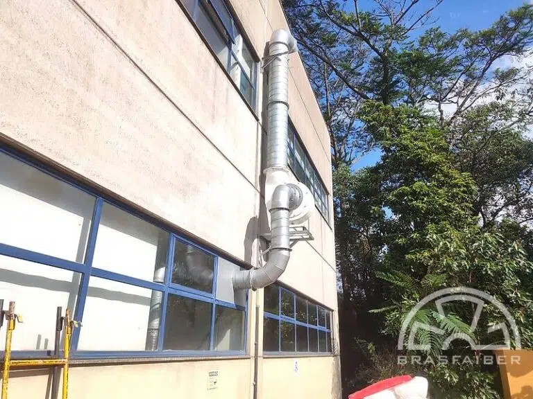 Exaustor centrífugo e tubulação de exaustão localizada instalados na fachada de uma indústria farmacêutica