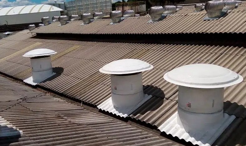 Exaustores de telhado instalados na cobertura para renovação de ar em galpão com calor de processo