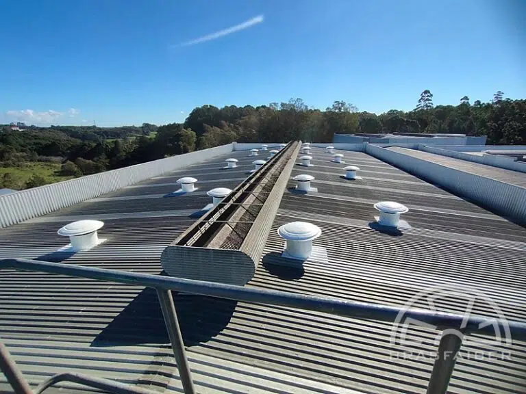 Exaustores axiais de telhado em PRFV instalados ao longo da cobertura de galpão industrial